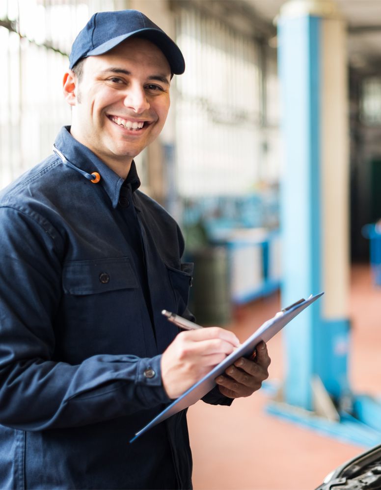 Happy technician ticking off a service sheet - Car & Light Commercial Servicing Lingfield