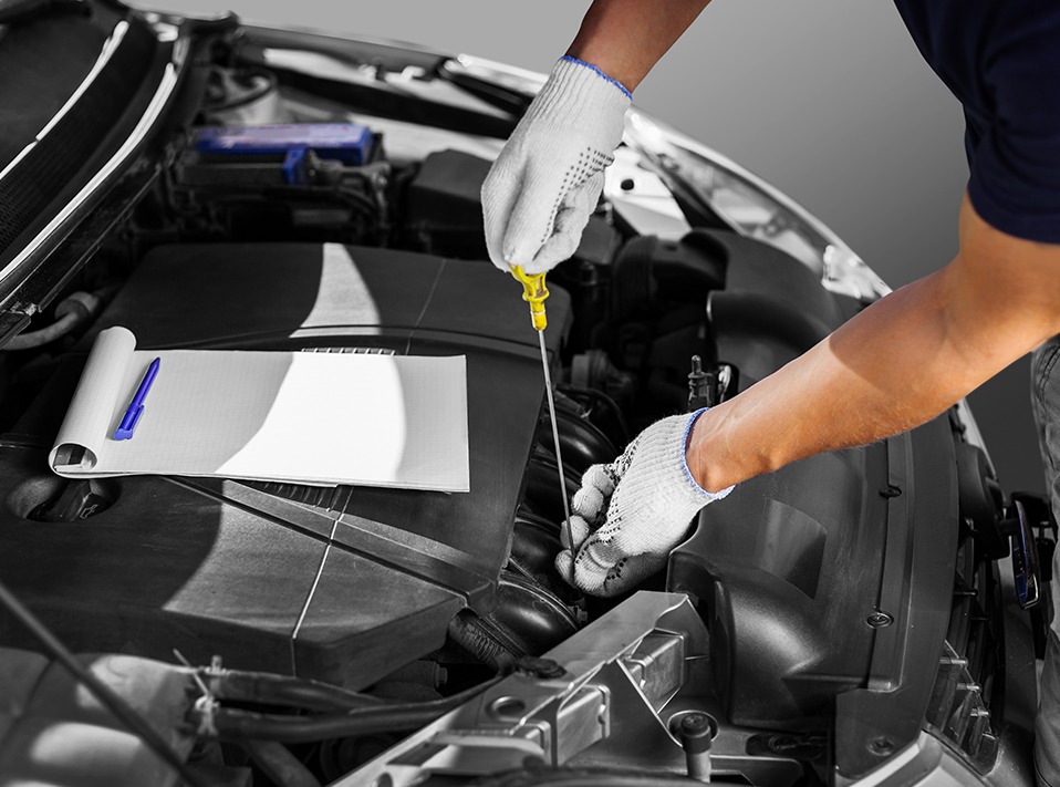 Mechanic checking a vehicles oil levels - Car Servicing Lingfield